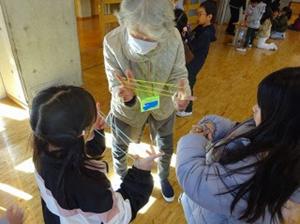 生活科の授業で、あやとりのやりかたを教えていただく常永小の児童